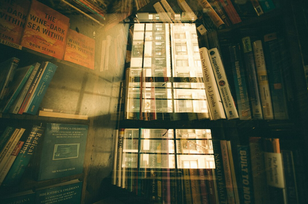 Dim library shelf with rows of old books