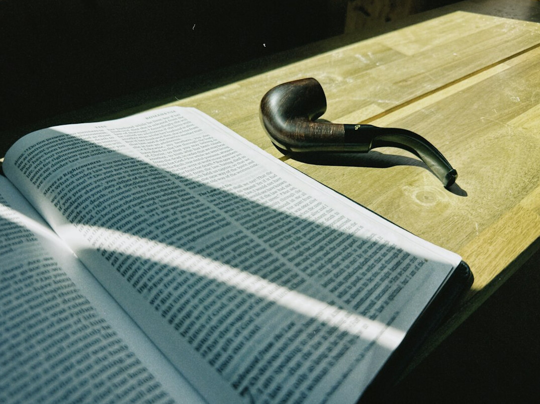 Open book with a magnifying glass on a wooden table